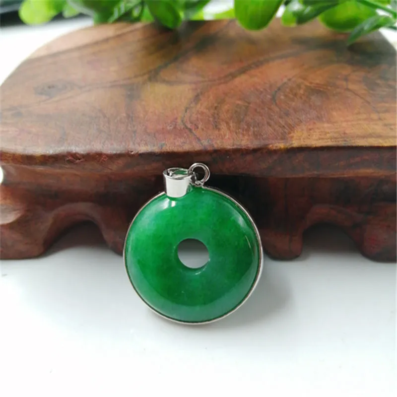 Emerald round jade pendant with gold inlaid safety buckle, modern simple geometry style, on a neutral background