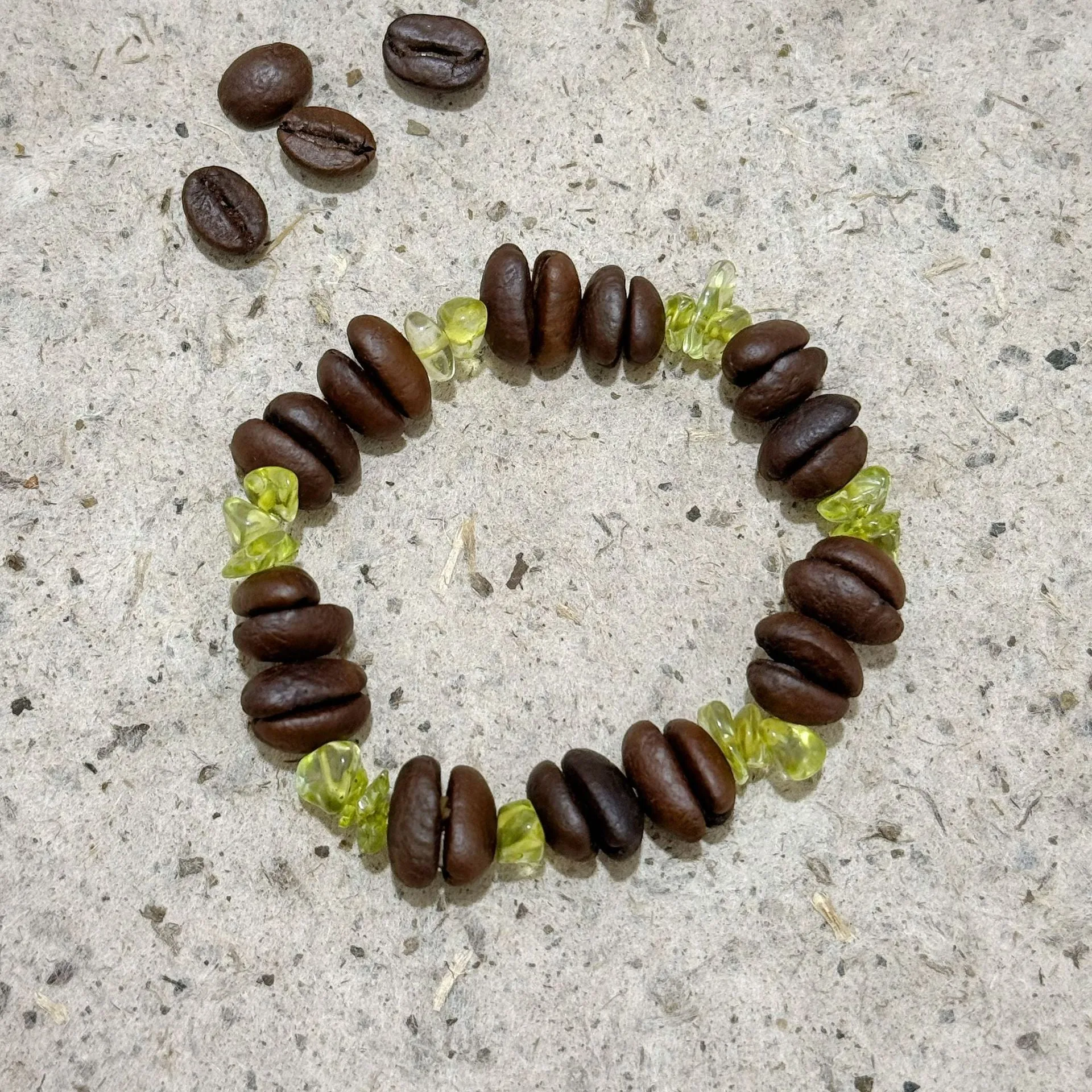 Handmade coffee bean bracelet with 16mm geometric charm showing colour variations