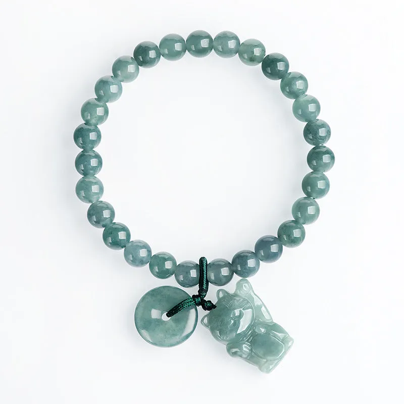 Hand woven bracelet with natural emerald beads and blue water lucky cat charm on a white background