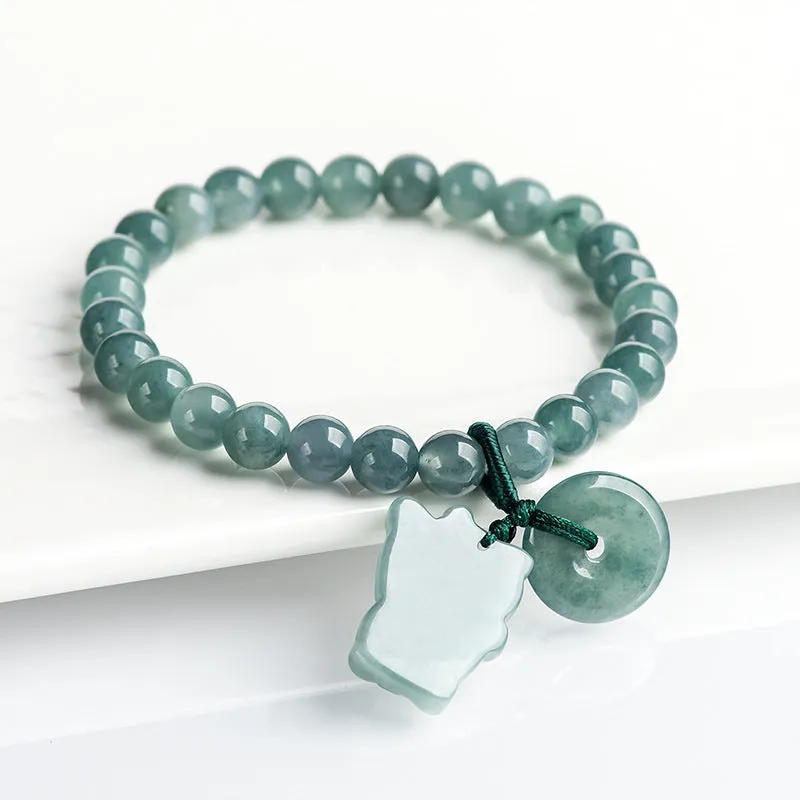 Hand woven bracelet with natural emerald beads and blue water lucky cat charm on a white background