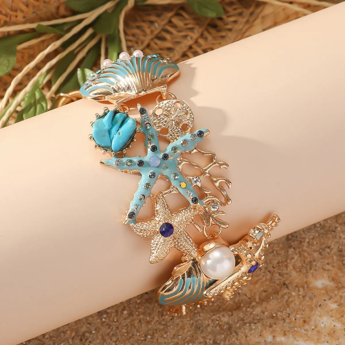 Women's alloy nautical bracelet with boat anchor and starfish charms in coral blue, red, or turquoise.