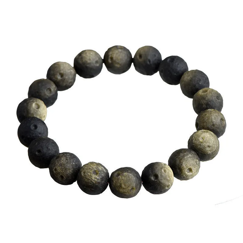 Natural obsidian crater ball bracelet with textured beads in gold or silver stone finish on a wrist.