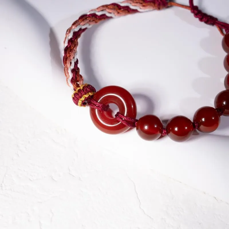 Red agate carrying strap bracelet with elk element on neutral background