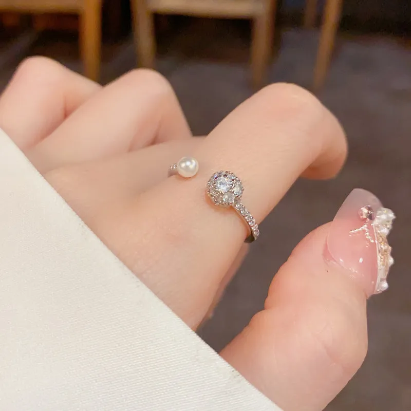 Gold and silver coloured open-end ring with round zircon on a geometric band.