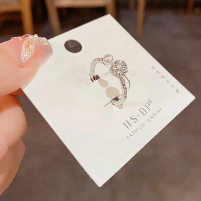 Gold and silver coloured open-end ring with round zircon on a geometric band.