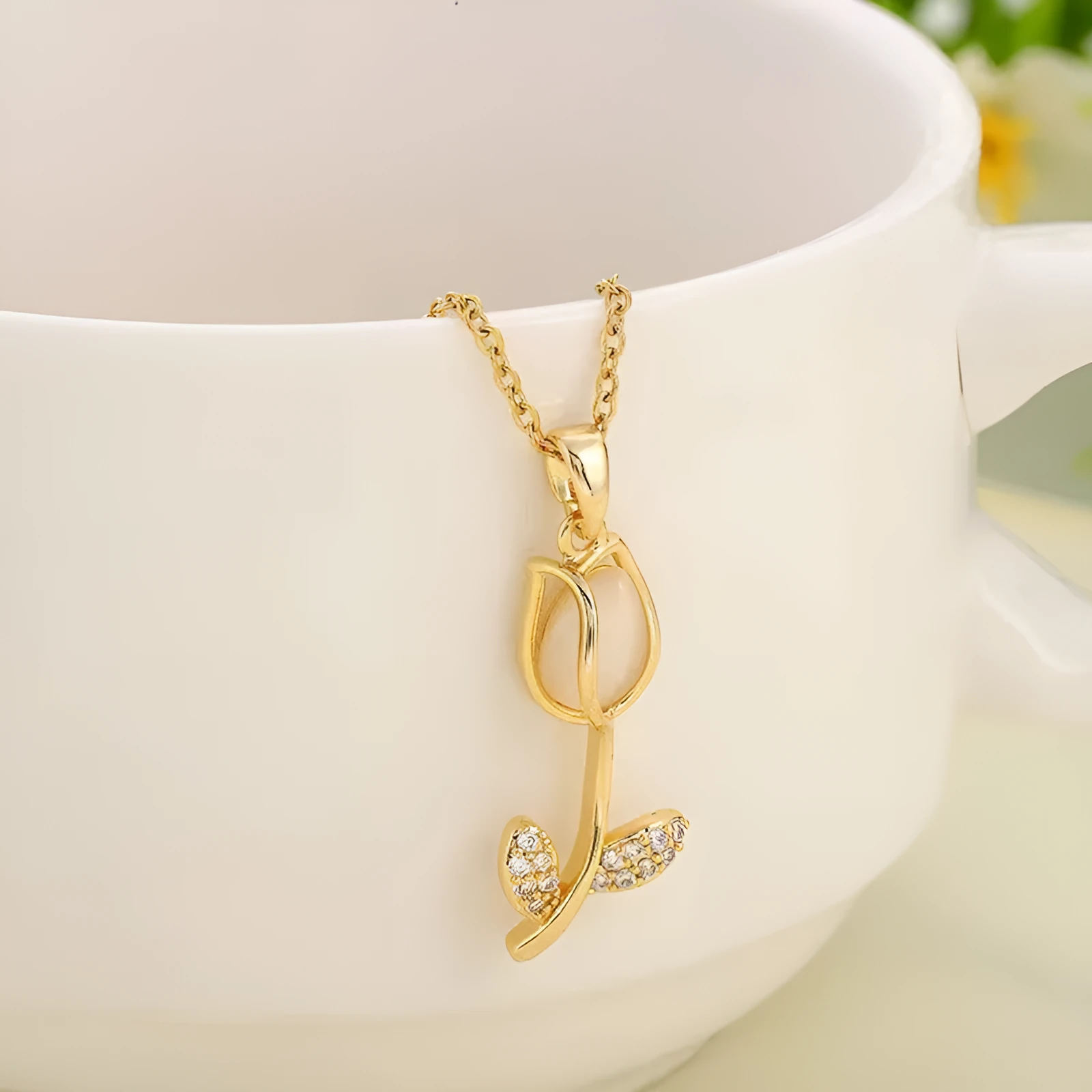 Gold-toned titanium steel necklace with a floral tulip pendant on an O-ring chain.