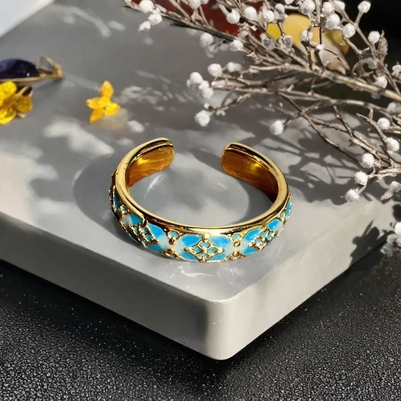 A copper vintage-style ring with a gourd motif, floral and bow designs, inlaid zircon stones, and an adjustable opening.