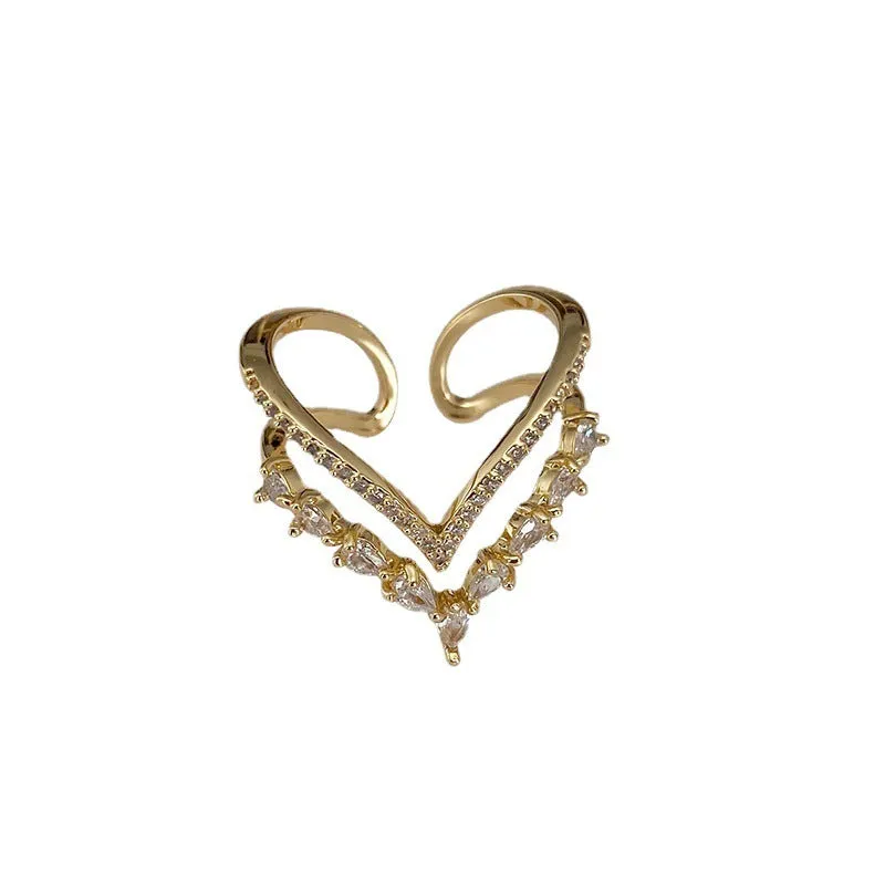 Gold plated copper heart shaped ring with full diamond detailing on white background