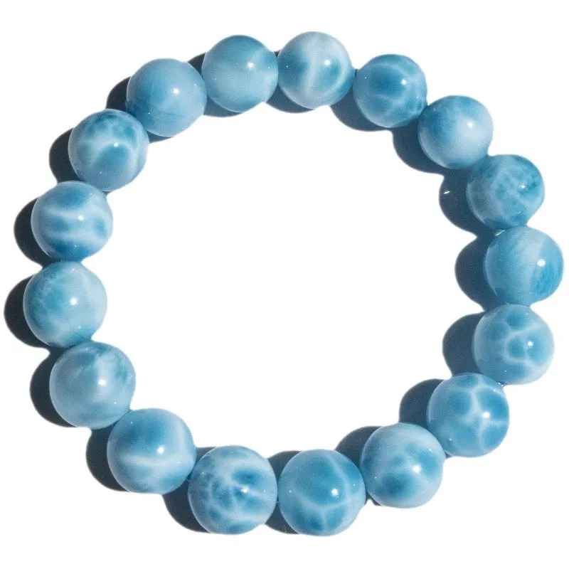 Blue handmade Bodhi bead bracelet with natural crystal and sea-pattern stone on a wrist.