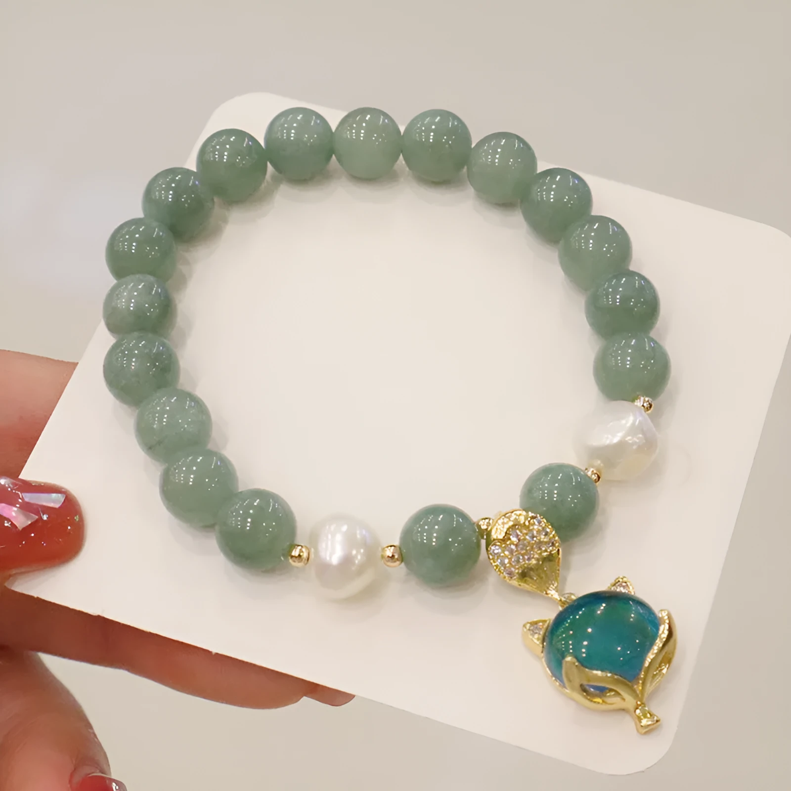 Burma jade warm fox pendant bracelet with temperature-sensitive feature and freshwater pearl accent on white background