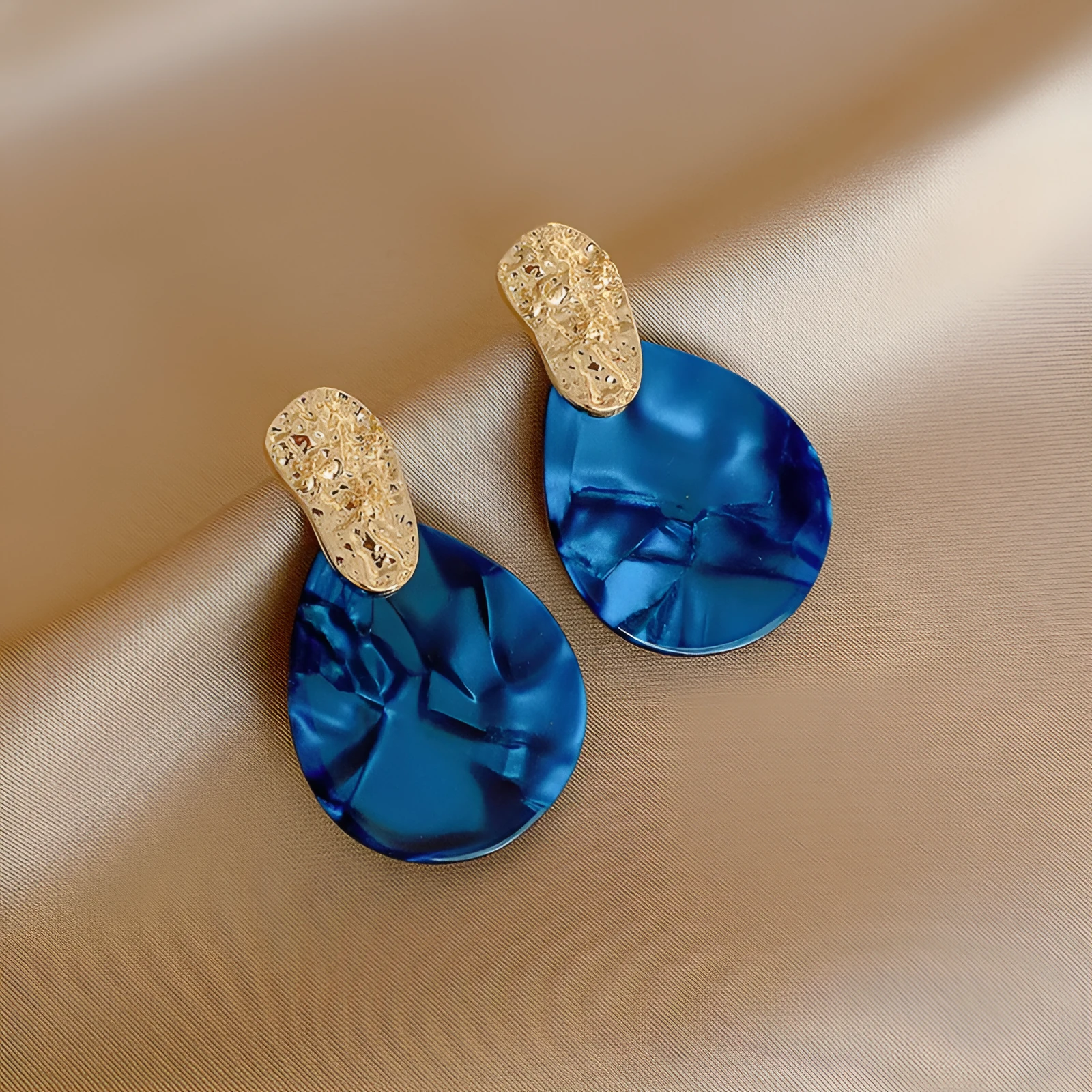 Silver Needle blue acrylic water drop ear studs with pleated texture on white background