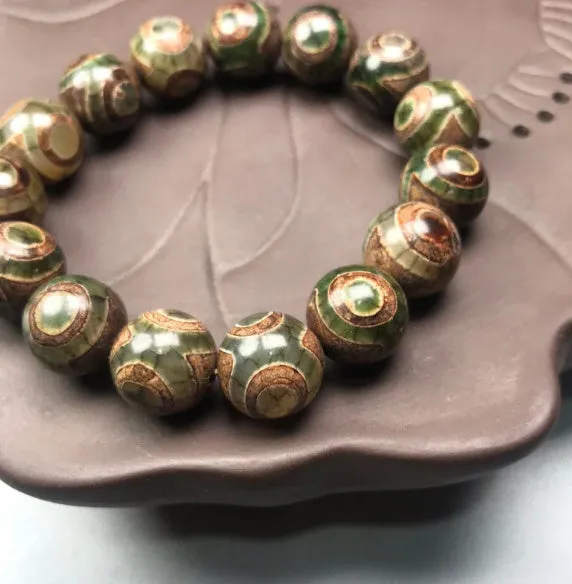 Natural agate men's bracelet with 14mm green three-eye round beads on a neutral background