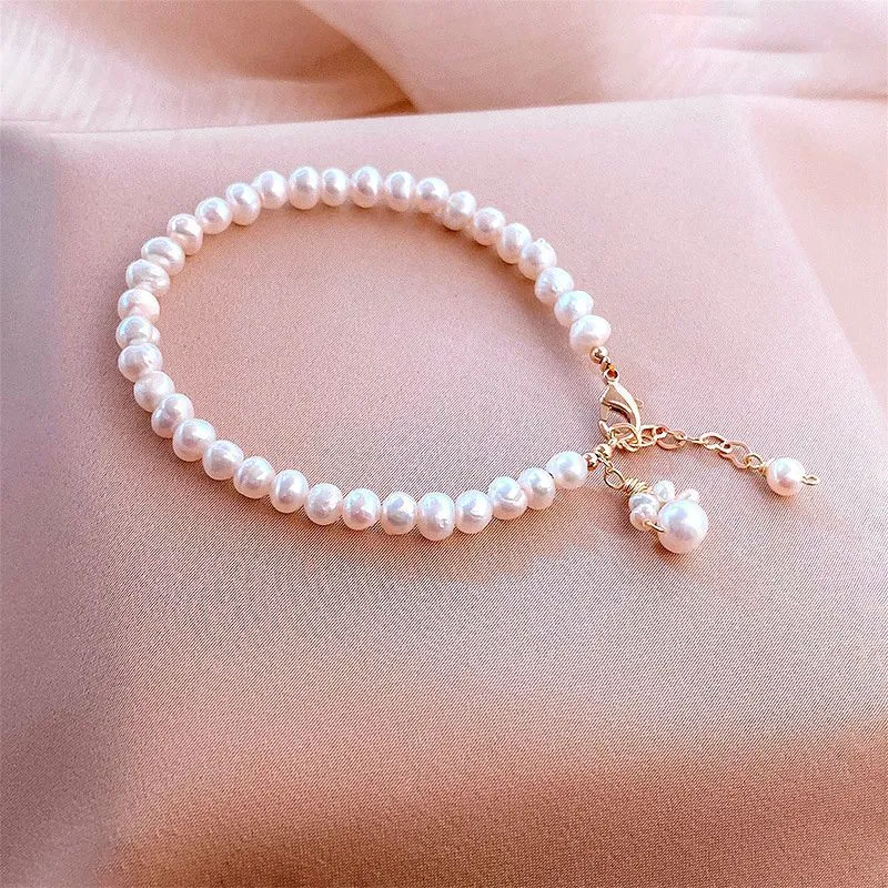 Women's white freshwater pearl cat's paw bracelet with electroplating finish on a neutral background