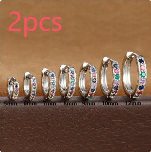 Set of three pairs of perforated circle stud earrings in gold, rose gold, and silver colours on a plain background.
