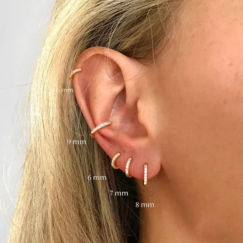 Set of three pairs of perforated circle stud earrings in gold, rose gold, and silver colours on a plain background.