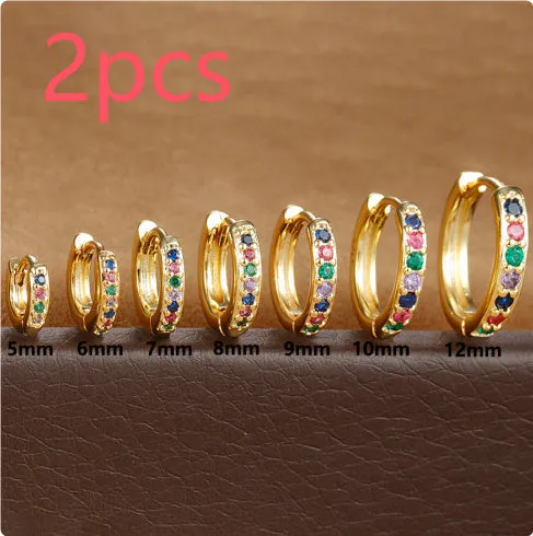 Set of three pairs of perforated circle stud earrings in gold, rose gold, and silver colours on a plain background.