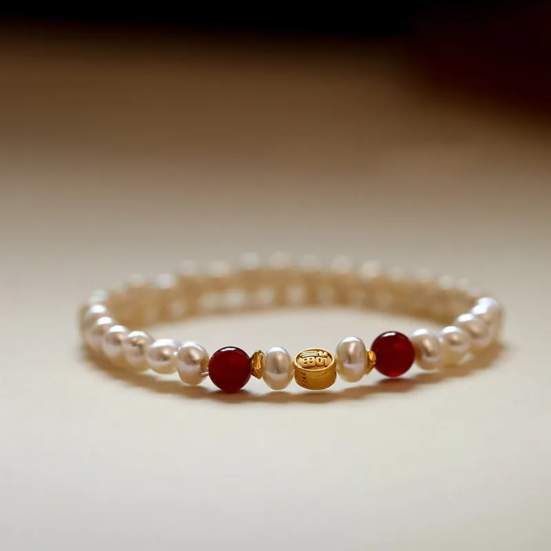 Natural freshwater pearl bracelet with Fu character charm on white background, silver chain, women's accessory