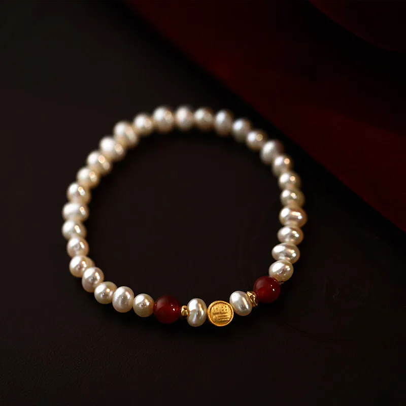 Natural freshwater pearl bracelet with Fu character charm on white background, silver chain, women's accessory