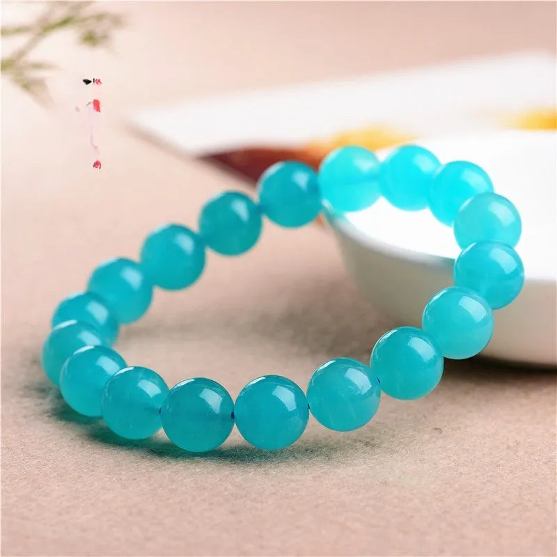 Selection of natural green Amazonite scattered beads in different sizes on a white background.