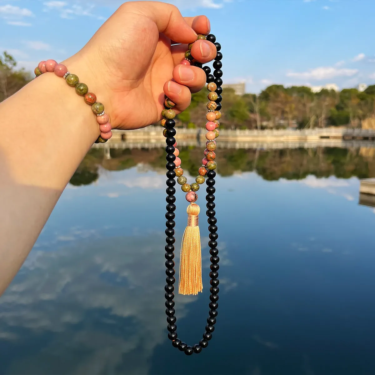 Natural unakite stone 108 prayer beads mala necklace and matching bracelet on neutral background