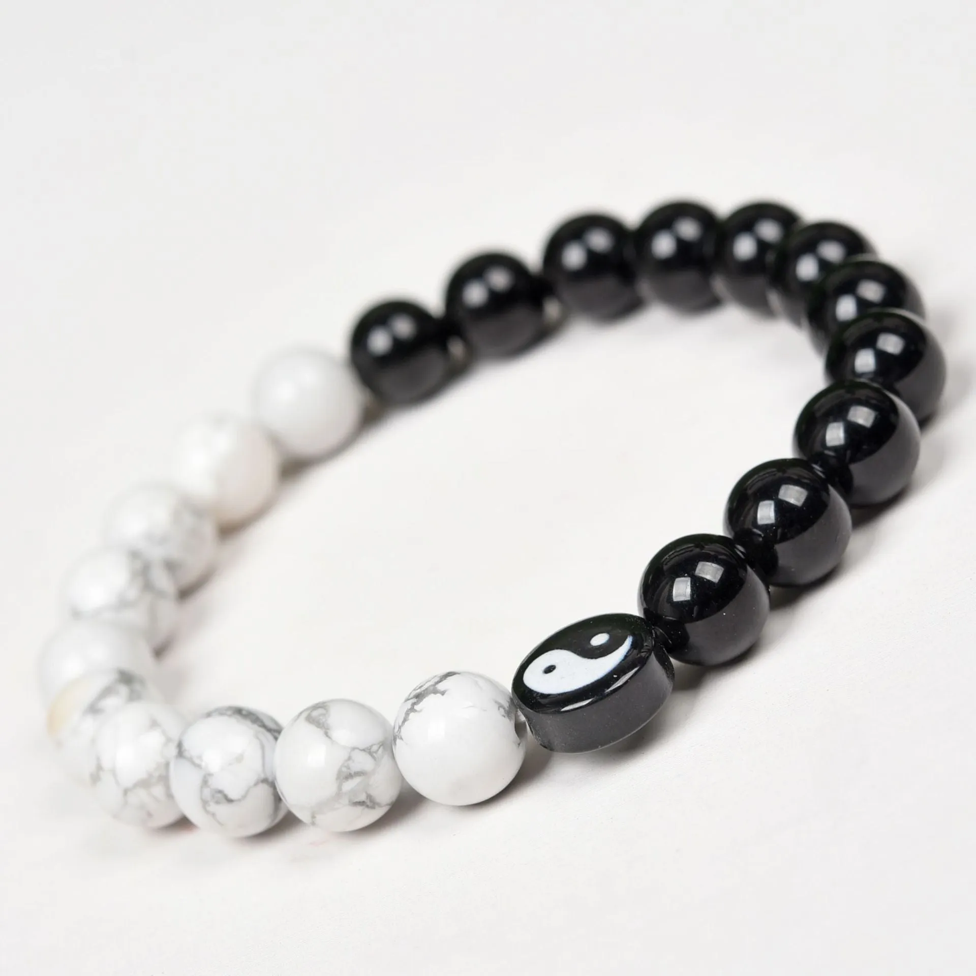 White turquoise and natural obsidian 8mm bead bracelet on a flat surface