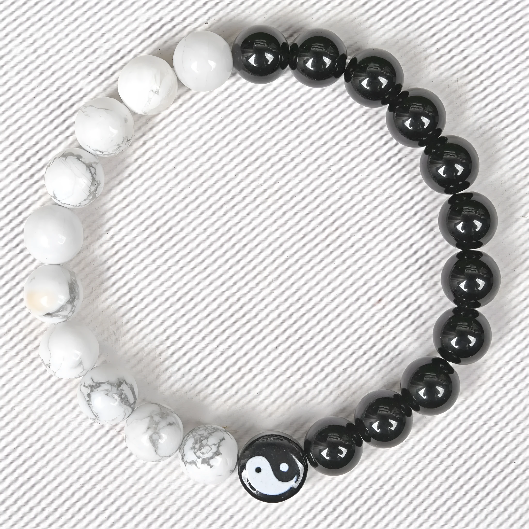 White turquoise and natural obsidian 8mm bead bracelet on a flat surface