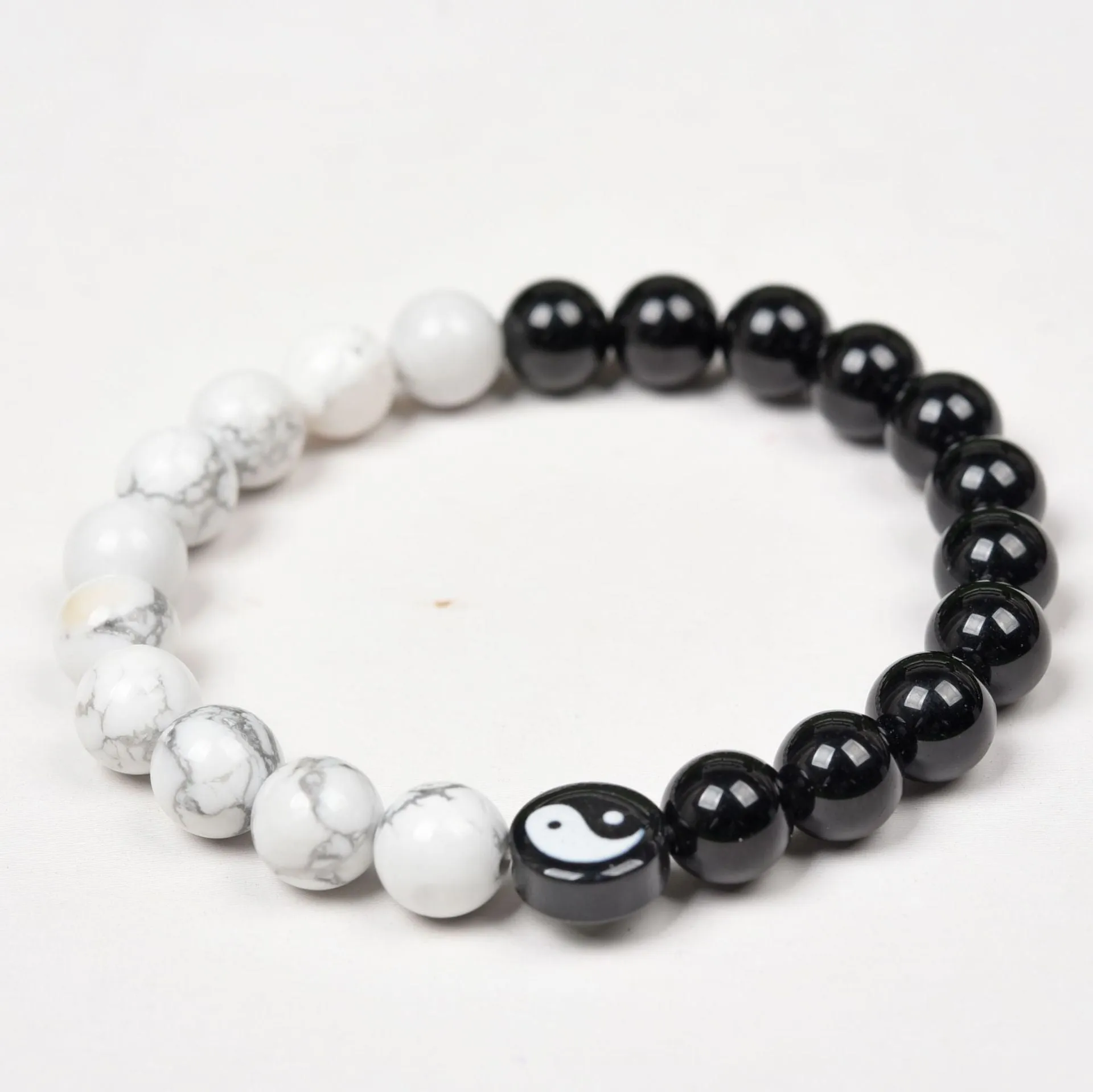 White turquoise and natural obsidian 8mm bead bracelet on a flat surface
