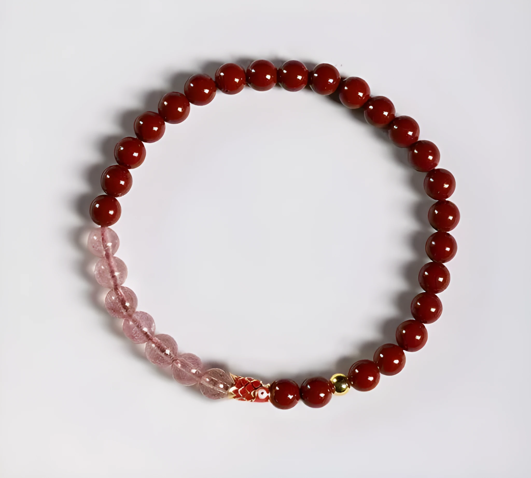 Hand-woven purple gold sand and strawberry quartz koi bracelet with crystal and pearl beads on a light background.