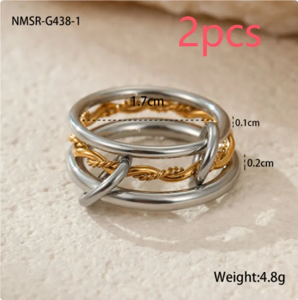 Stacked colour matching stainless steel ring with gold plating and exaggerated design on a woman's hand.