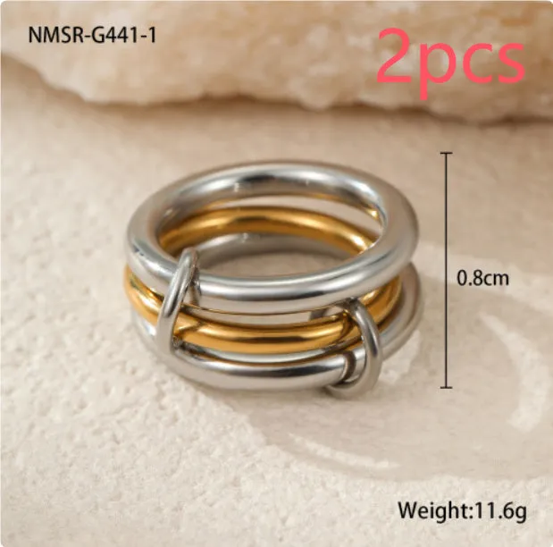 Stacked colour matching stainless steel ring with gold plating and exaggerated design on a woman's hand.