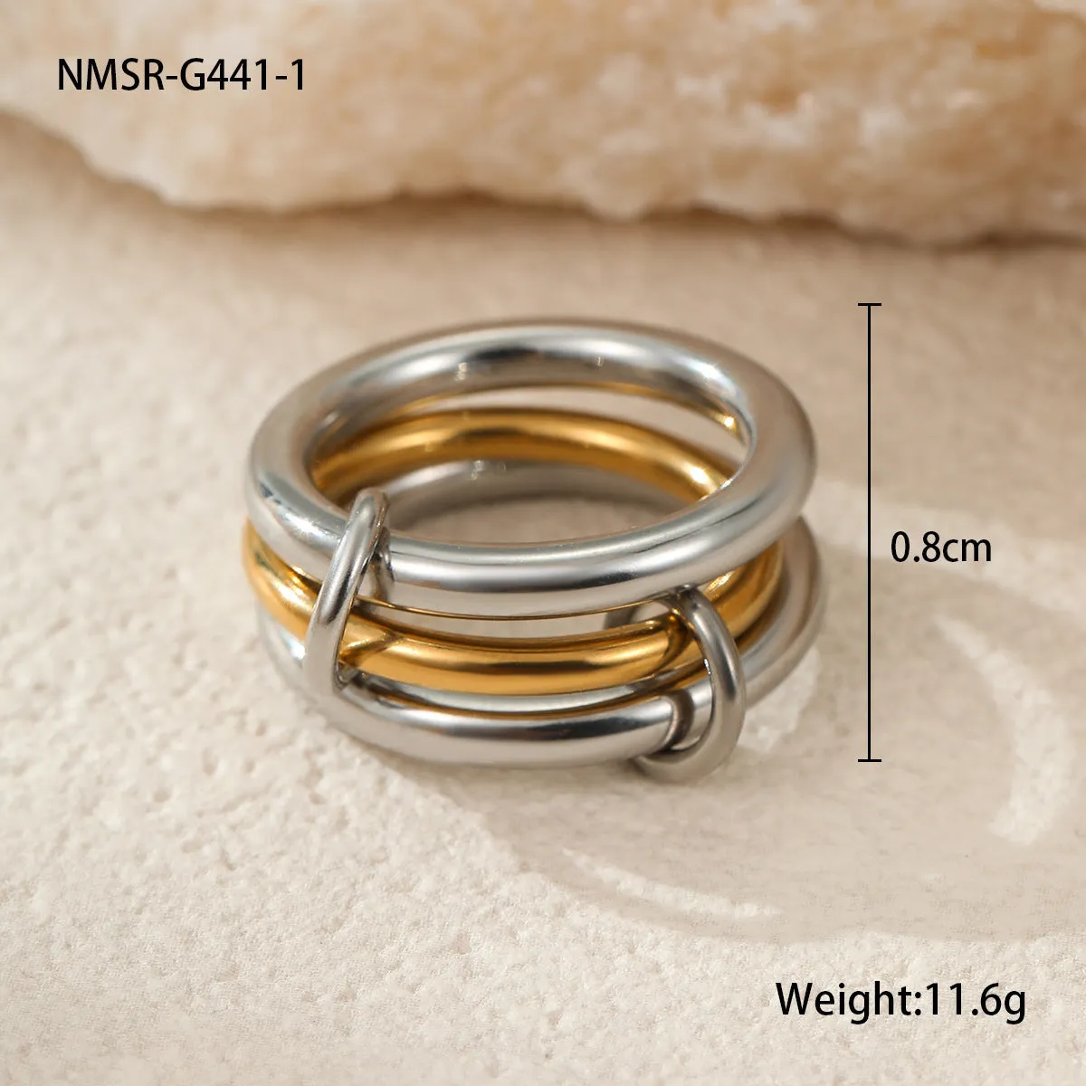 Stacked colour matching stainless steel ring with gold plating and exaggerated design on a woman's hand.
