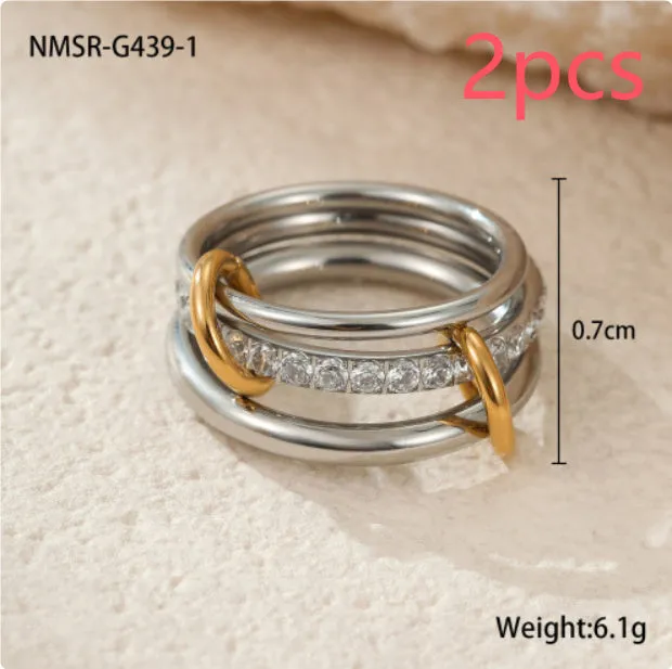 Stacked colour matching stainless steel ring with gold plating and exaggerated design on a woman's hand.