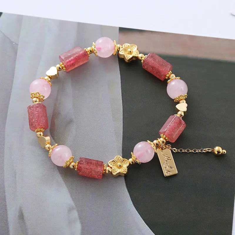 Pink strawberry crystal bracelet with star-shaped beads and a small heart charm on a white background