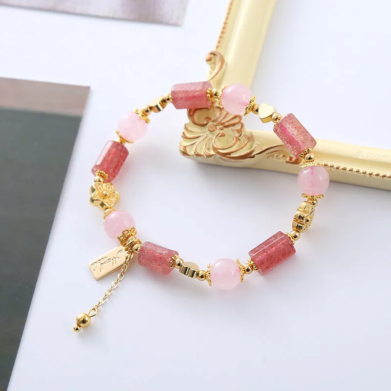 Pink strawberry crystal bracelet with star-shaped beads and a small heart charm on a white background