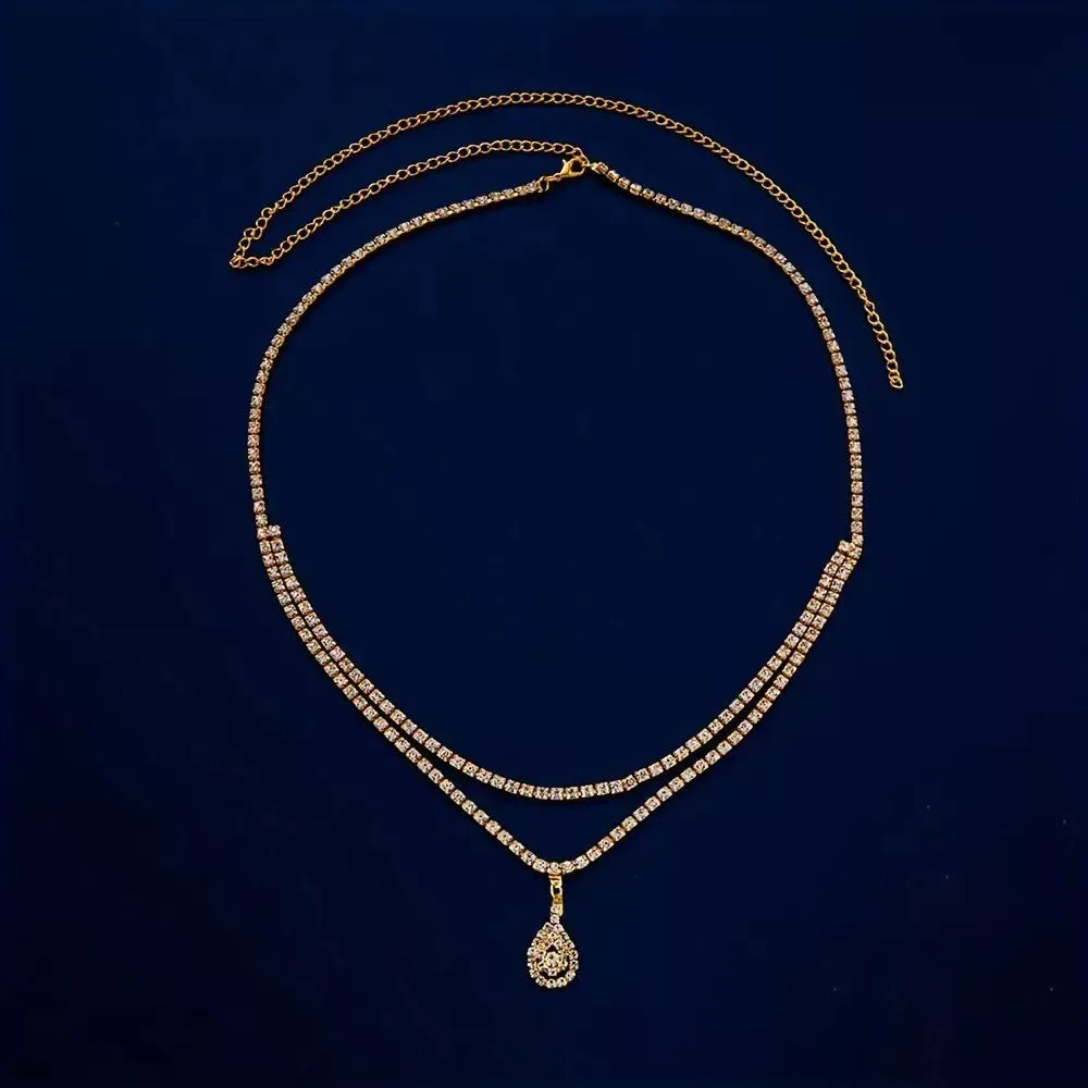 Gold rhinestone waist chain with water drop pendant and tassel detailing on adjustable 115 cm chain