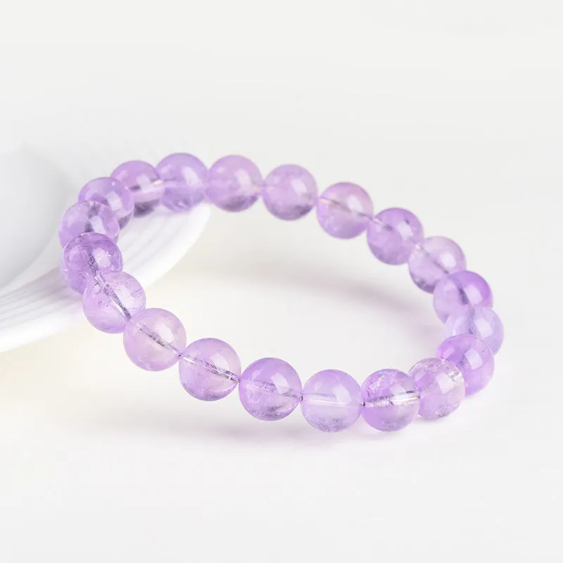 Lavender round amethyst crystal bead bracelet with water ripple design on a wrist.