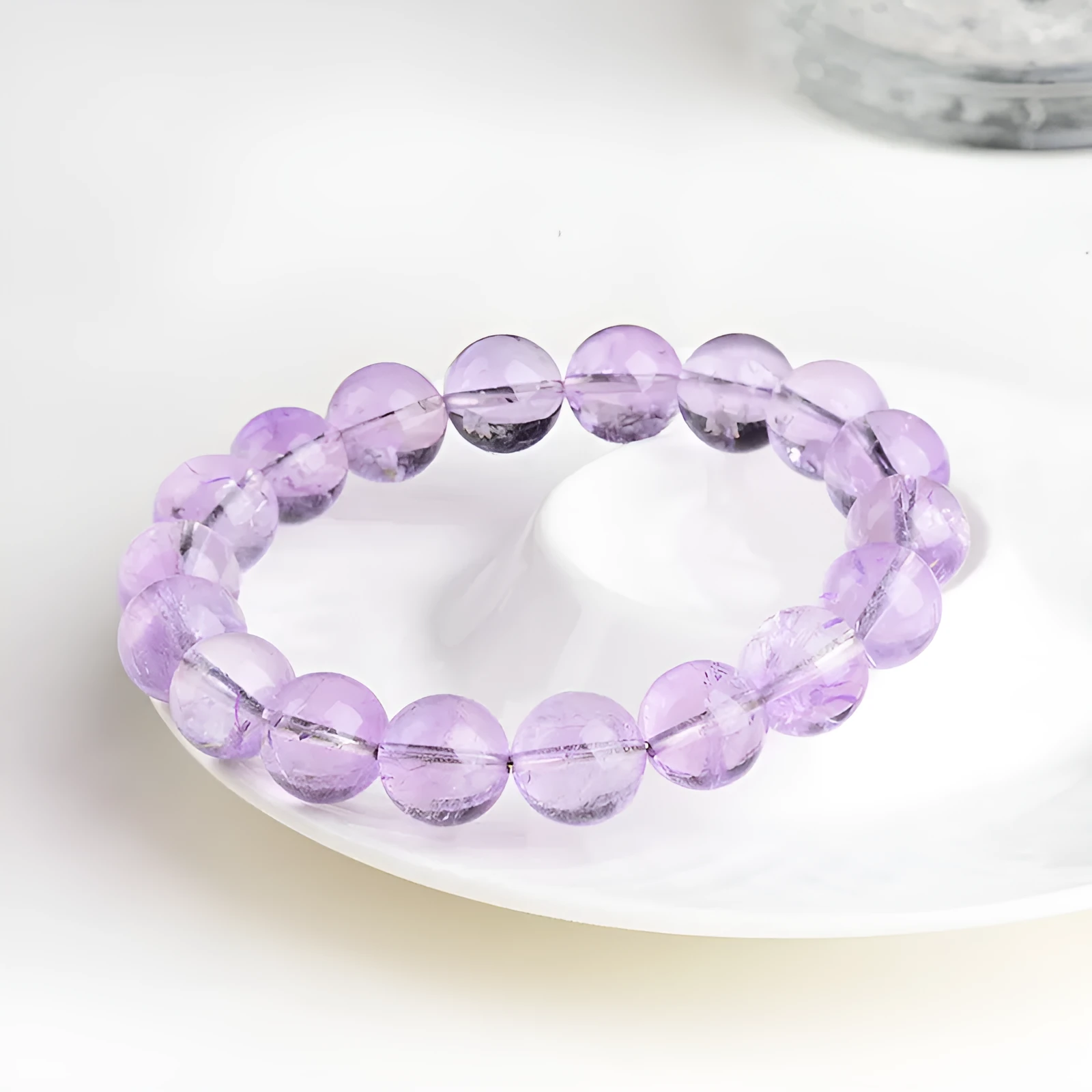 Lavender round amethyst crystal bead bracelet with water ripple design on a wrist.