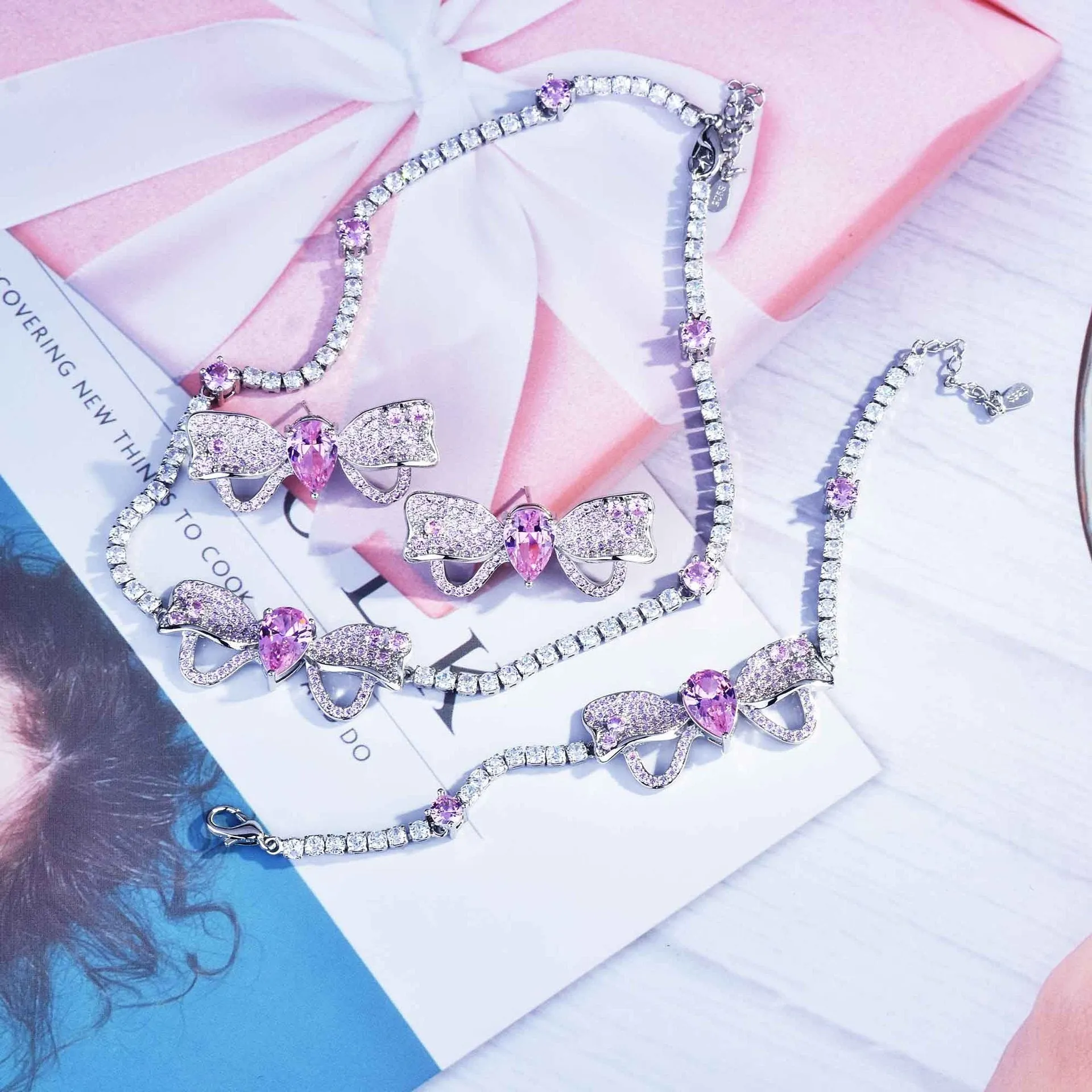Full diamond bow jewellery set with necklace, bracelet, and ear studs in copper with mixed gem inlay