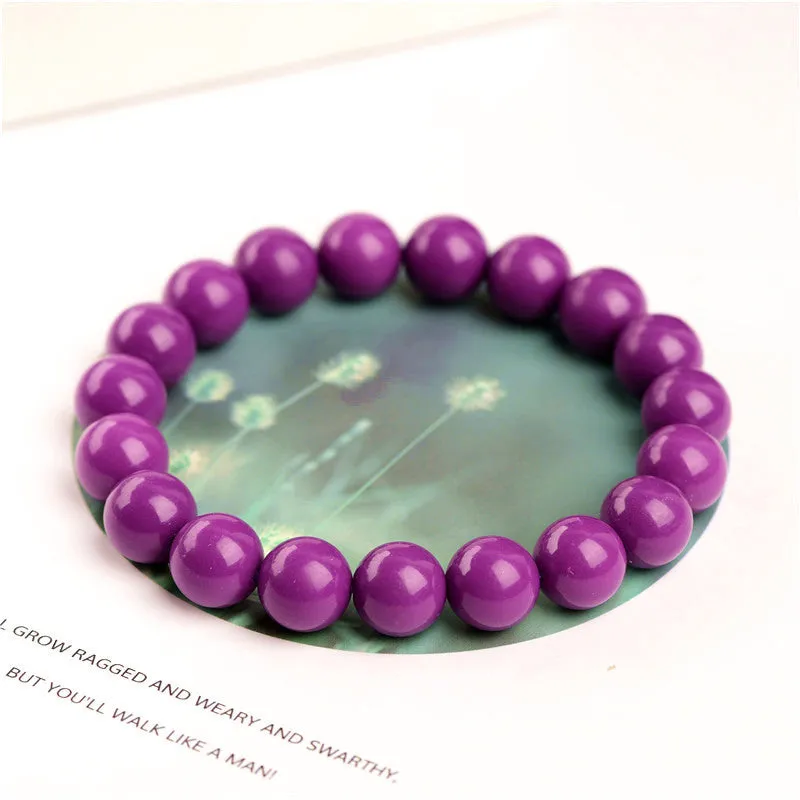 Close-up of a polished purple mica crystal bracelet with a single ring of beads on a wrist.
