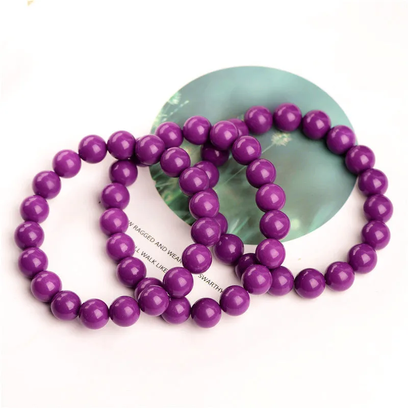 Close-up of a polished purple mica crystal bracelet with a single ring of beads on a wrist.