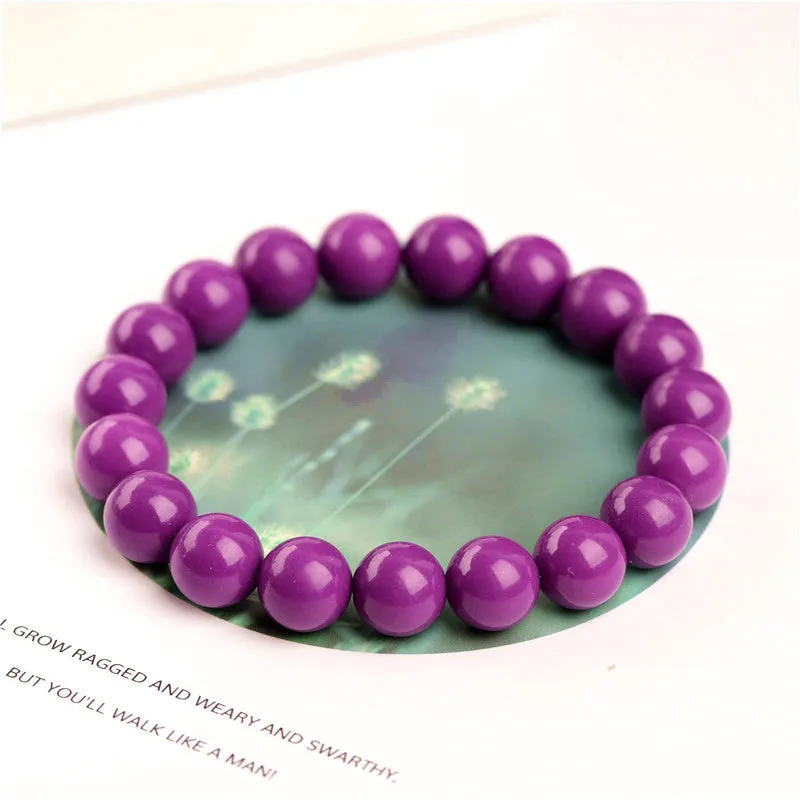 Close-up of a polished purple mica crystal bracelet with a single ring of beads on a wrist.
