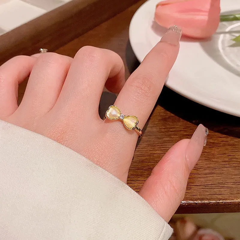 Geometric bow adjustable open ring in copper with electroplated gold finish on finger