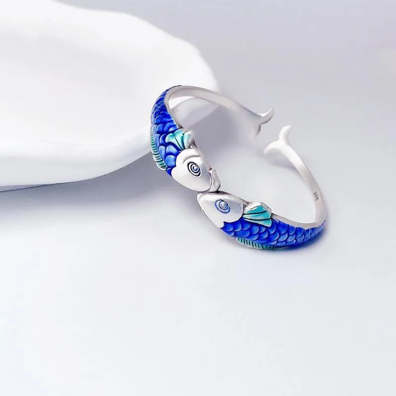 Silver electroplated copper bangle with blue carp design under glossy epoxy finish, 60mm diameter.