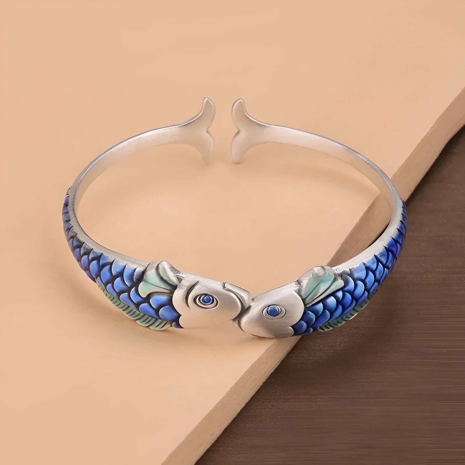 Silver electroplated copper bangle with blue carp design under glossy epoxy finish, 60mm diameter.