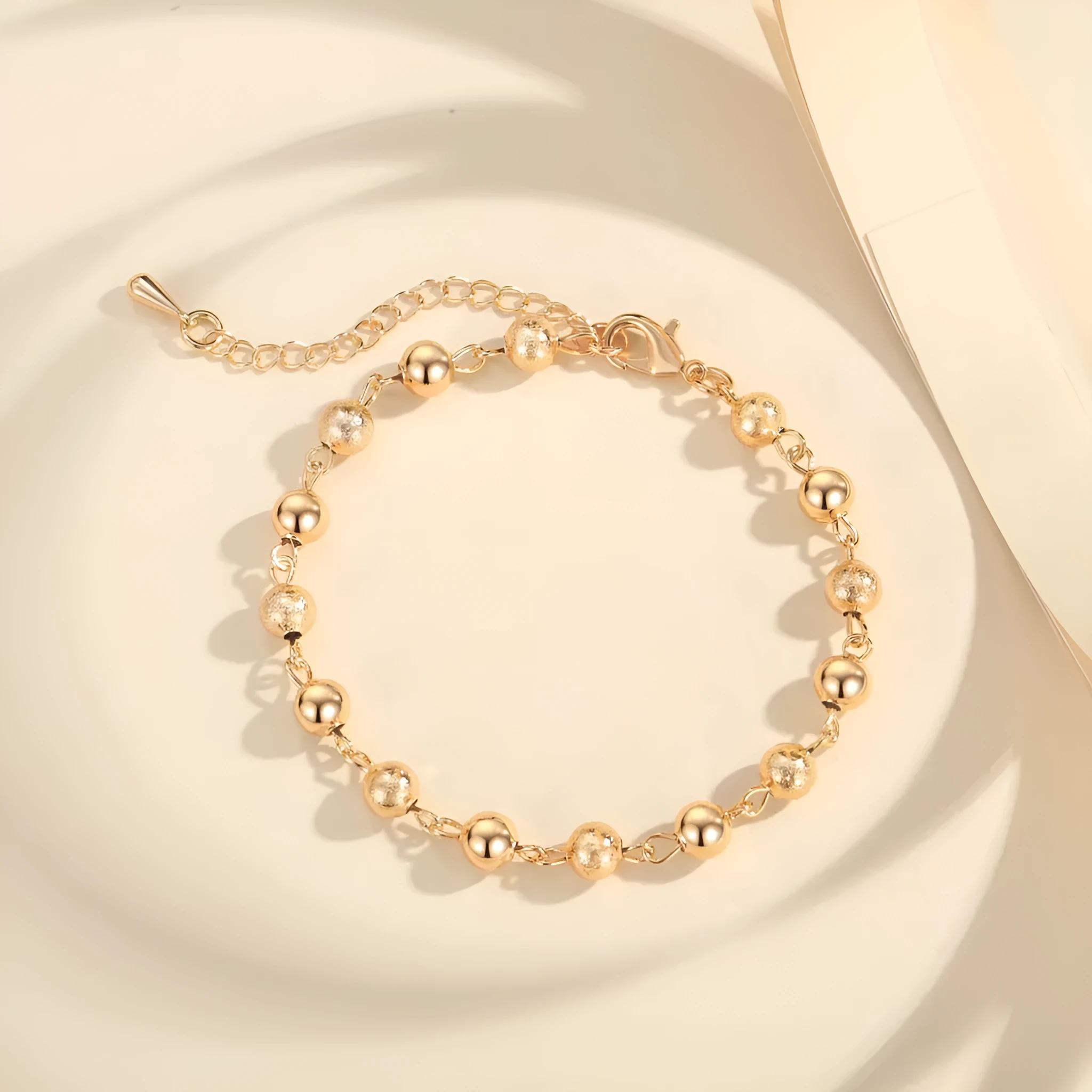 Gold electroplated copper unisex retro beaded bracelet on a neutral background