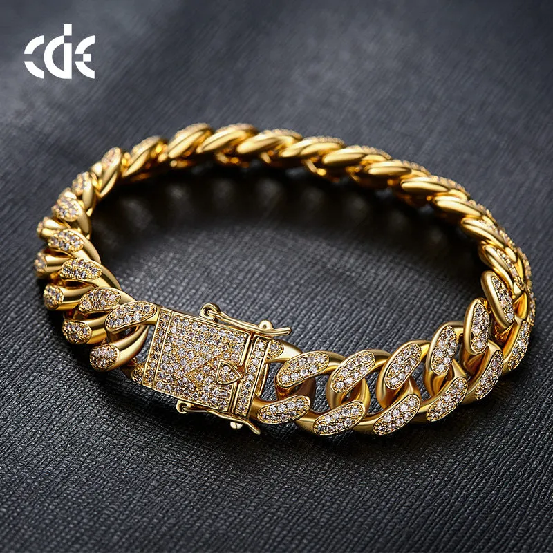 Men's Cuban chain bracelet with gold finish and geometric zircon pendant on a flat surface