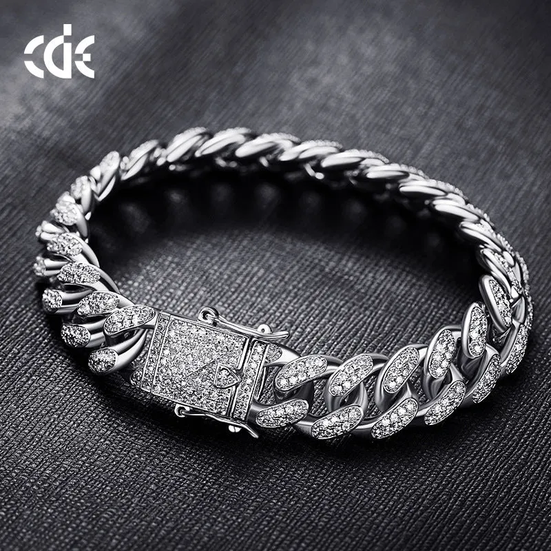 Men's Cuban chain bracelet with gold finish and geometric zircon pendant on a flat surface