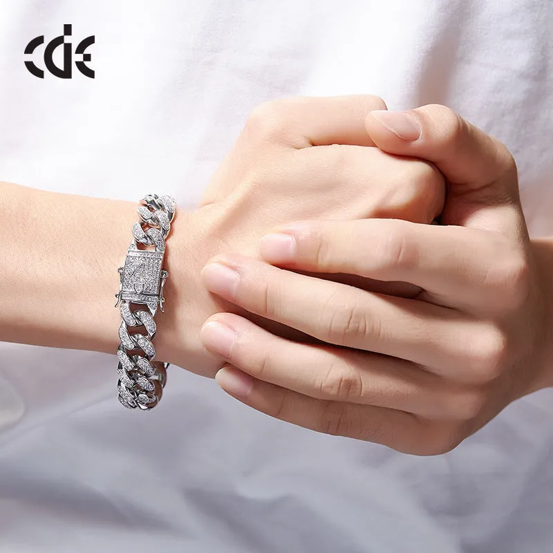 Men's Cuban chain bracelet with gold finish and geometric zircon pendant on a flat surface