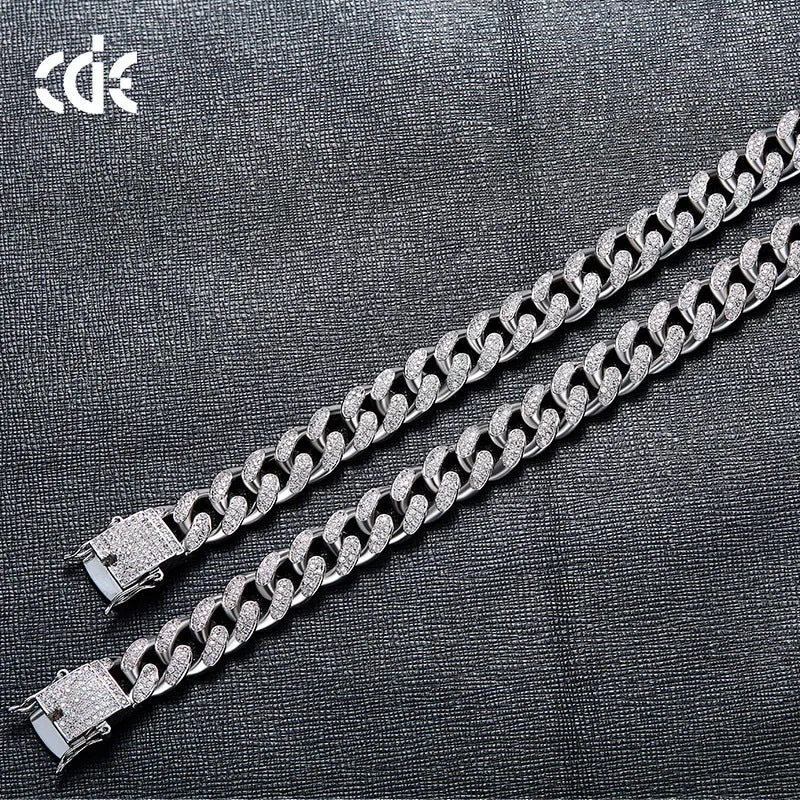 Men's Cuban chain bracelet with gold finish and geometric zircon pendant on a flat surface