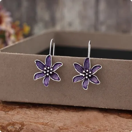 A pair of purple flower-shaped alloy stud earrings with a simple post back, shown against a plain background.